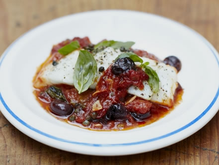 Peixe branco cozido com azeitonas e um molho de tomate